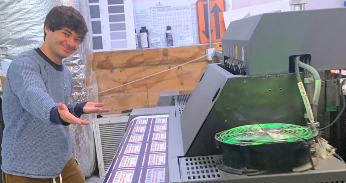 A man demonstrating how to use a large format printer