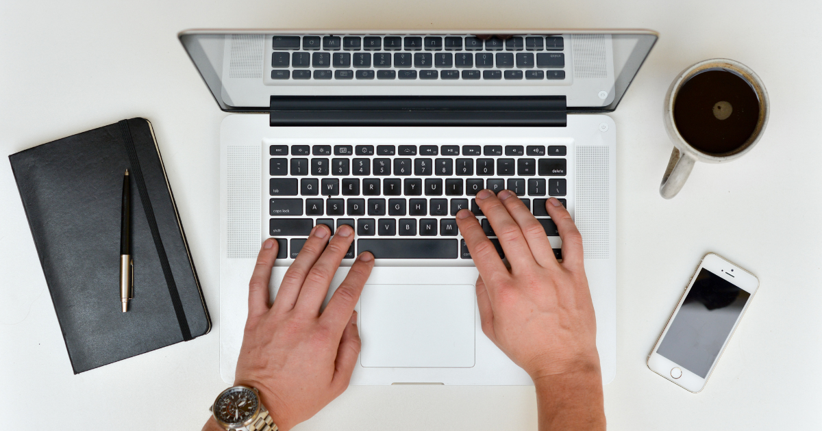 Hands typing on a laptop